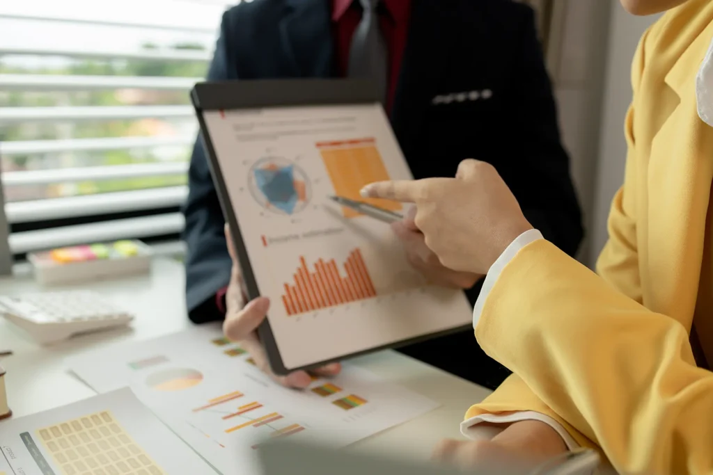 Due persone in abiti formali analizzano un grafico.